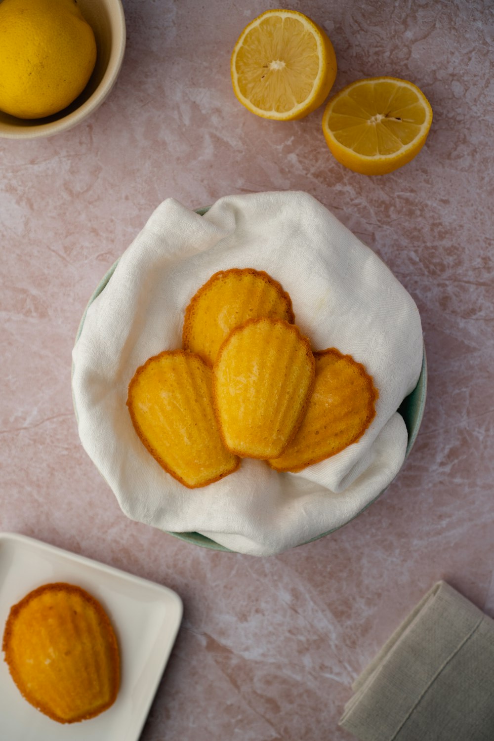 a bowl of peeled oranges next to a plate of sliced oranges