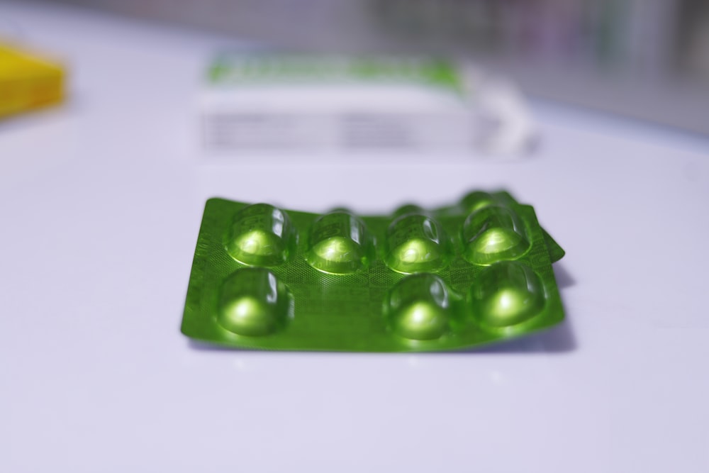 a group of green pills sitting on top of a table
