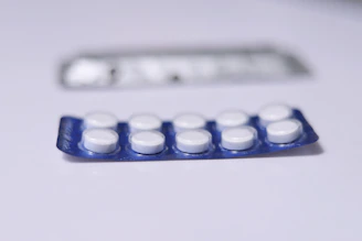 Close-up of a blister pack filled with round, white pharmaceutical tablets branded with Elite Pharma logo