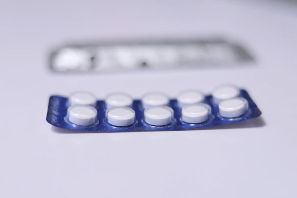 Close-up of a blister pack filled with smooth, round tablets on a clean white surface.