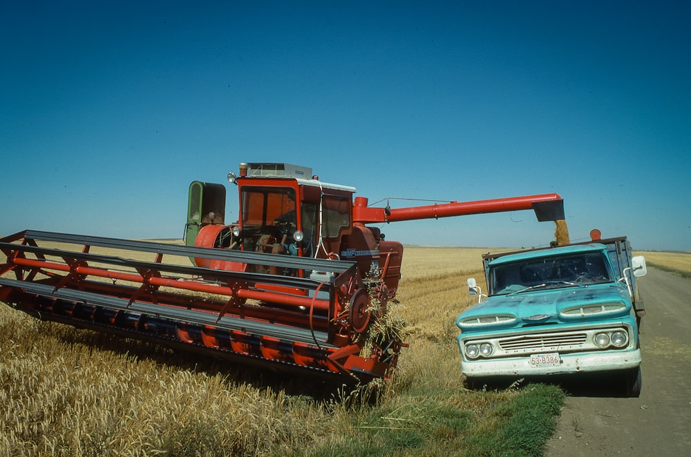 a blue truck and a red and white truck in a field