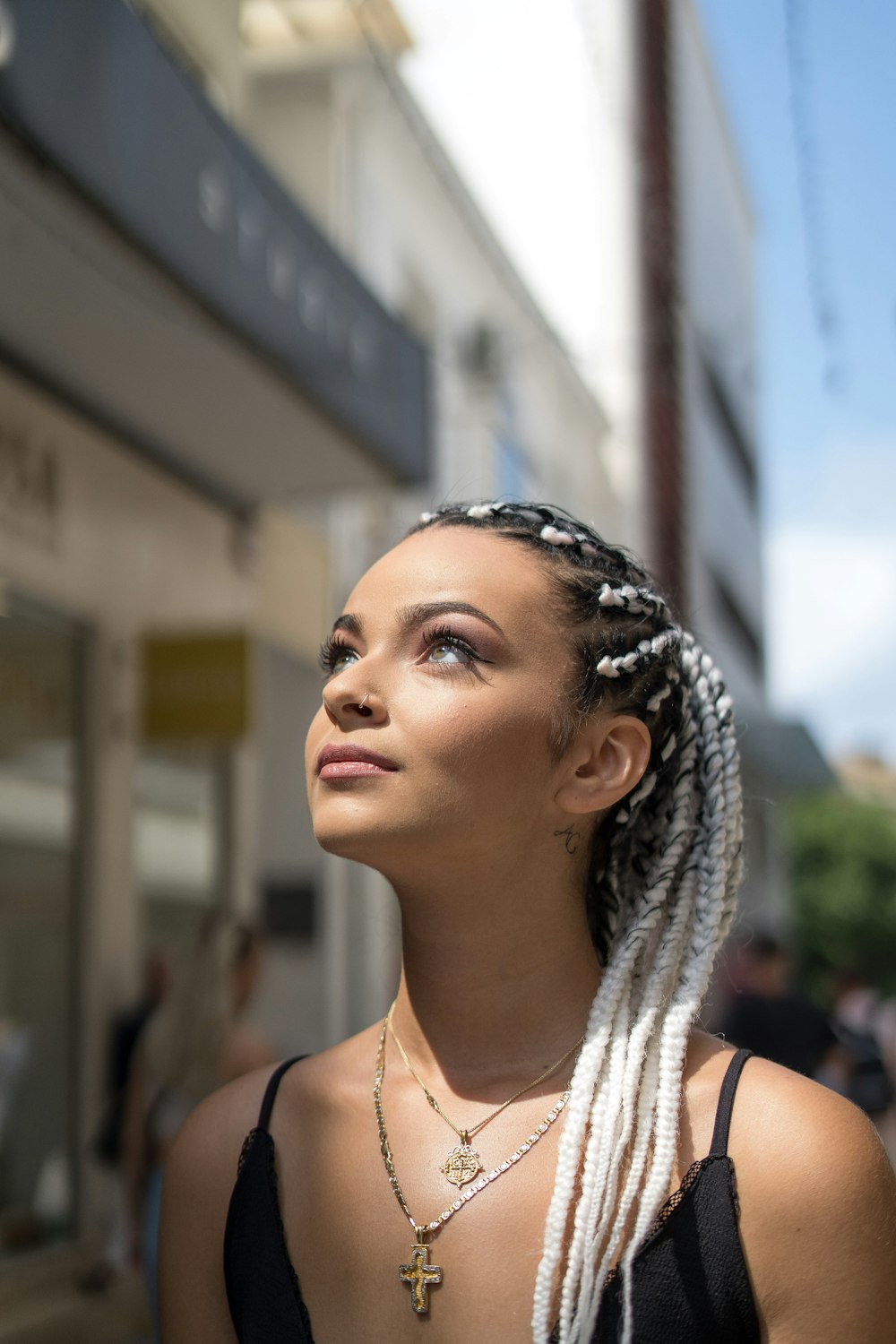 a woman with braids standing on a city street