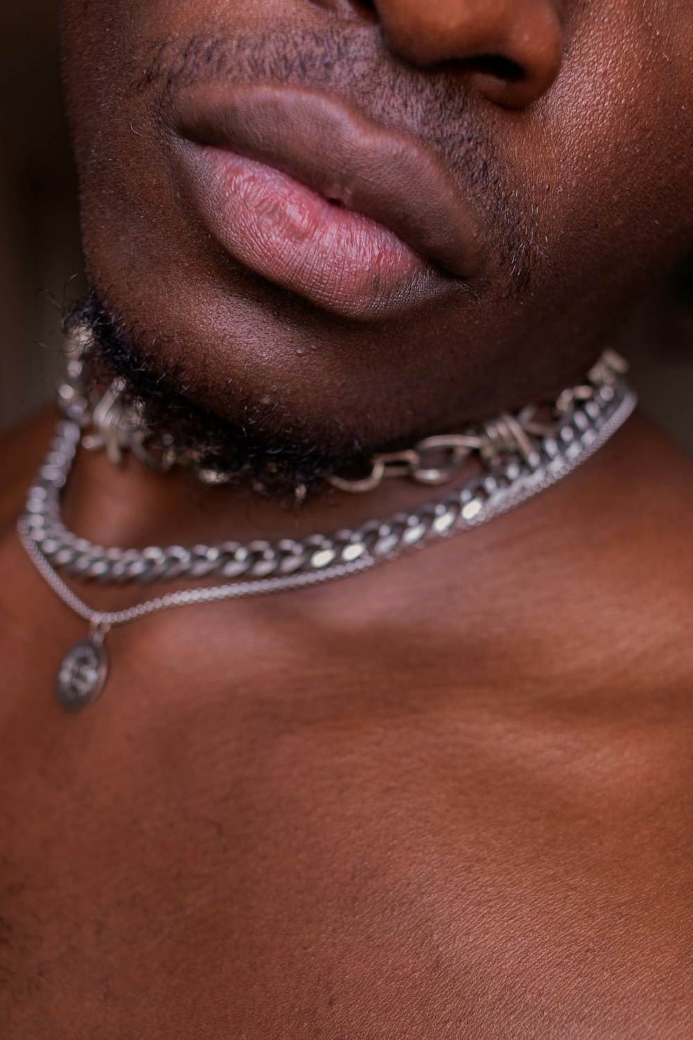 a close up of a man wearing a chain around his neck