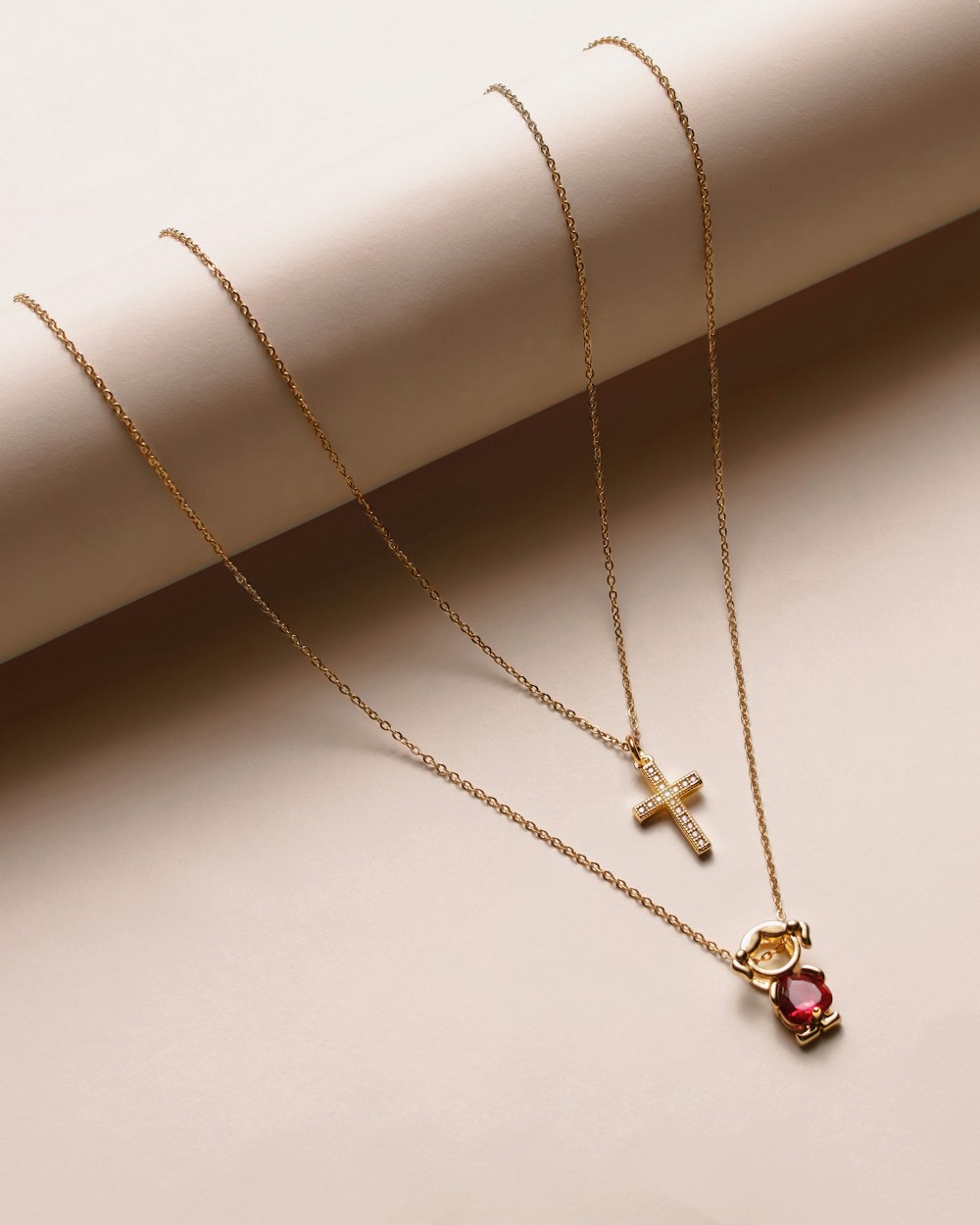 two necklaces with a cross and a heart