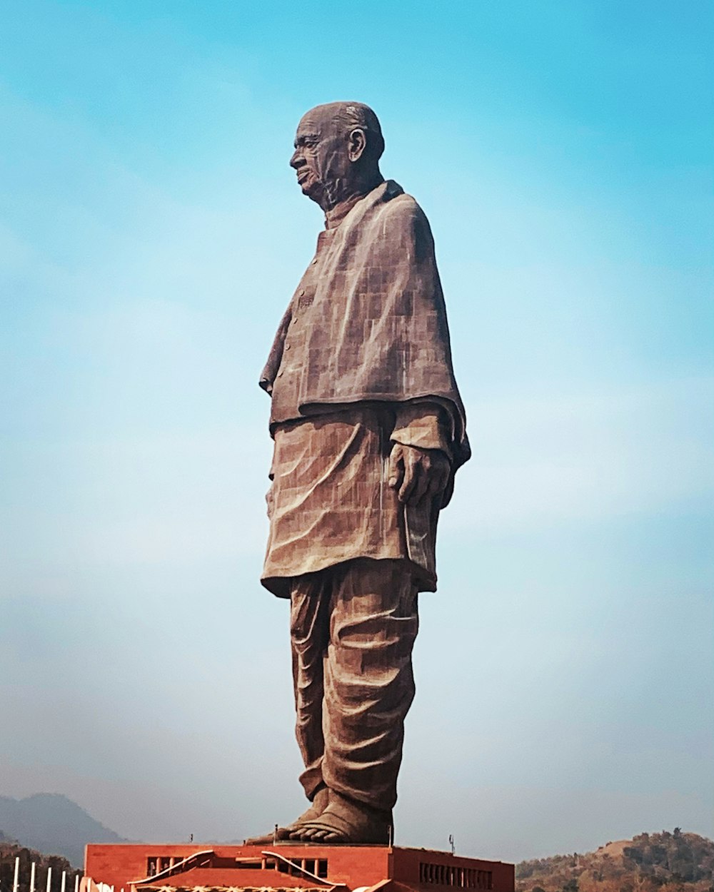 a large statue of a man standing in front of a building