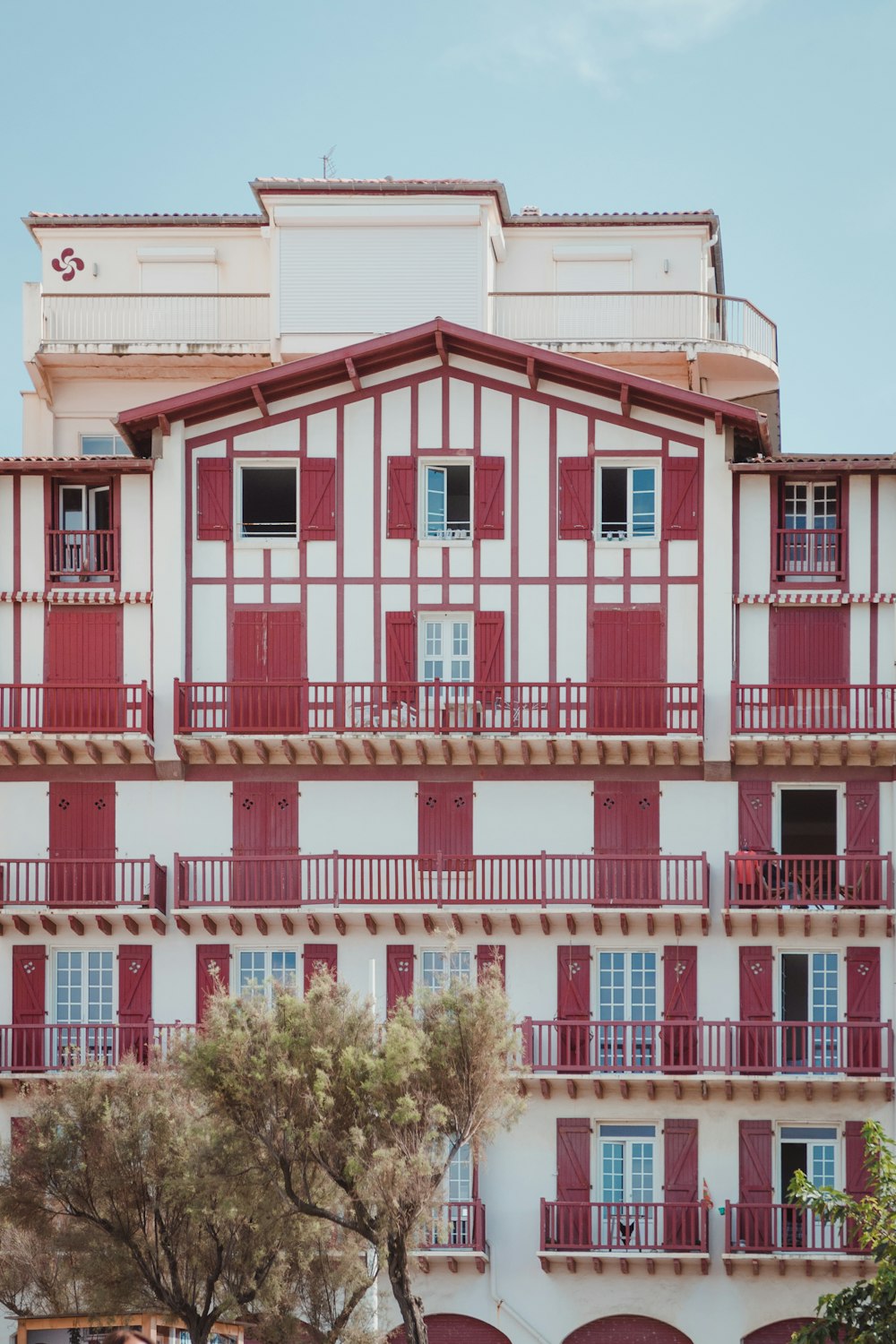 a tall building with red and white balconies