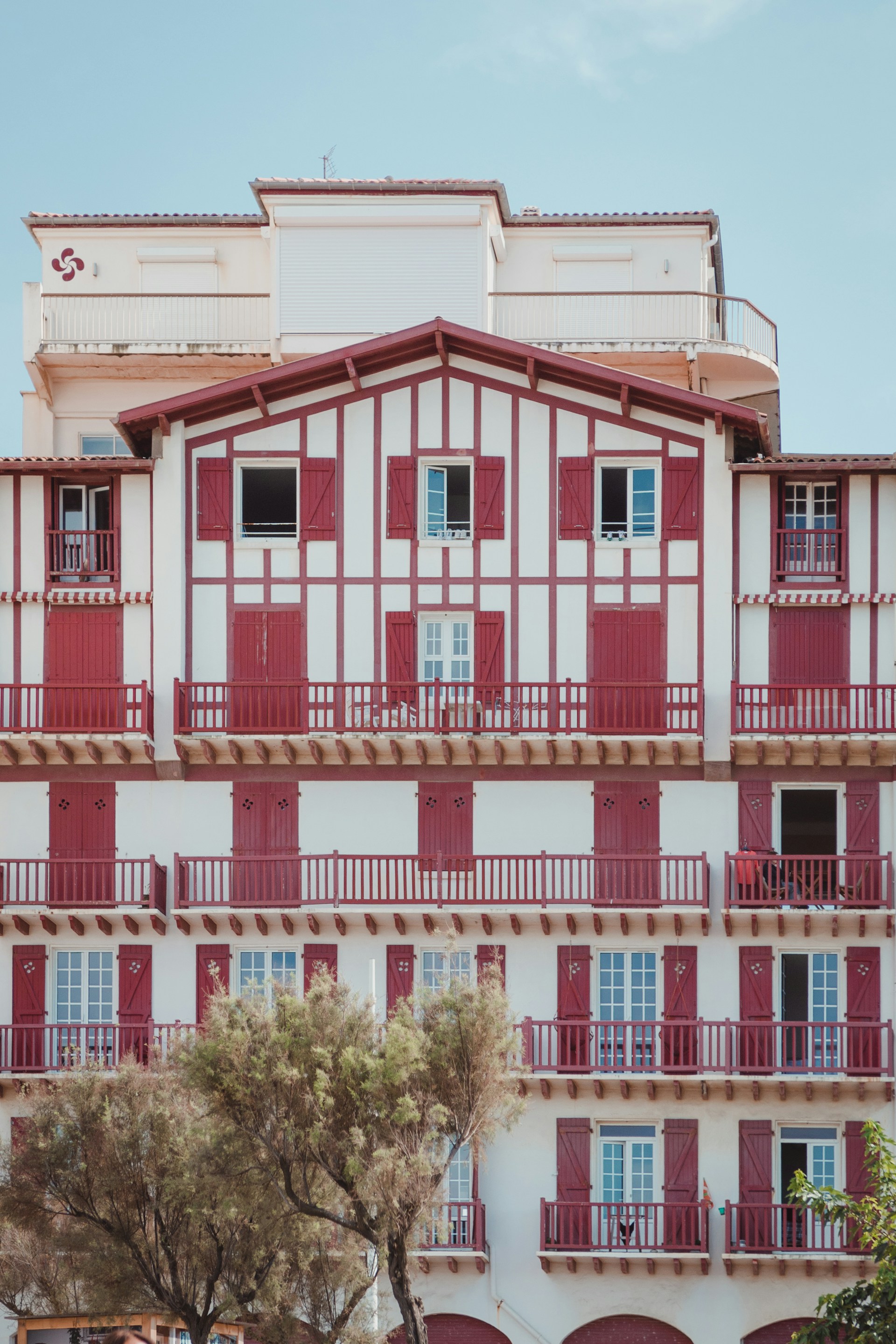 a tall building with red and white balconies
