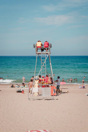 Lifeguard attentively watching over a busy pool filled with families enjoying a sunny day.