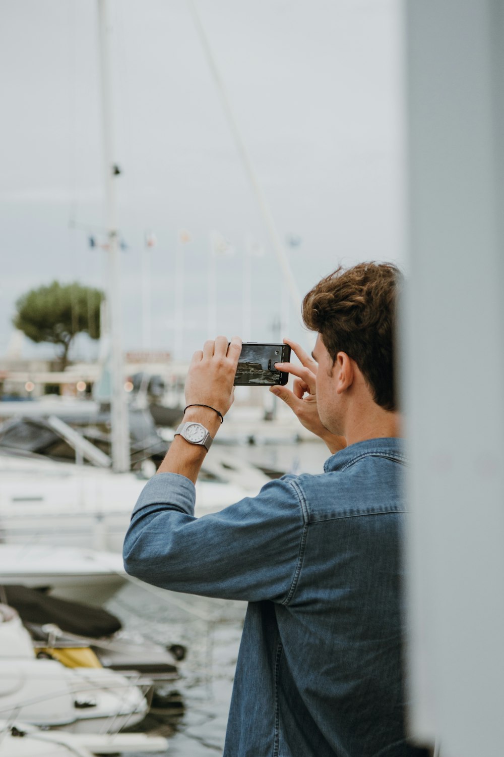 a man taking a picture of a boat in the water