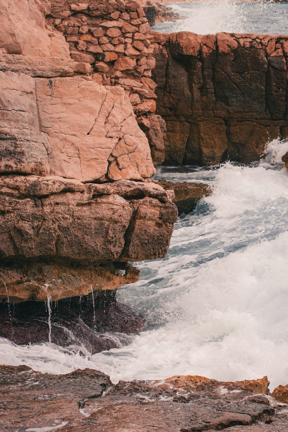 a man standing on top of a cliff next to a body of water