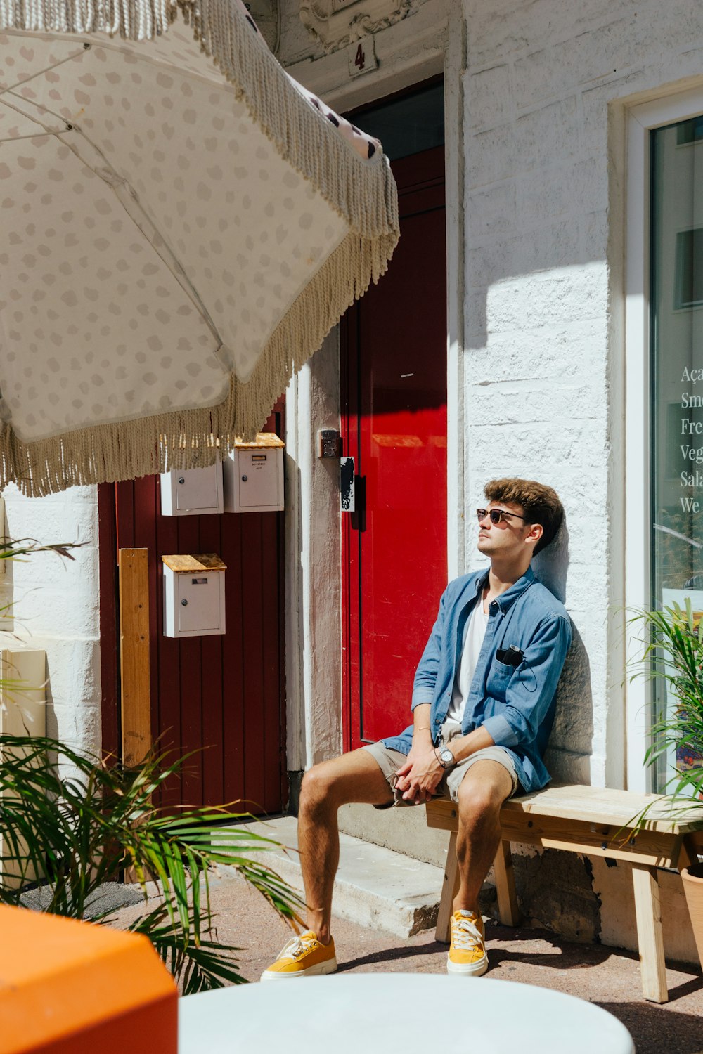 a man sitting on a bench in front of a building