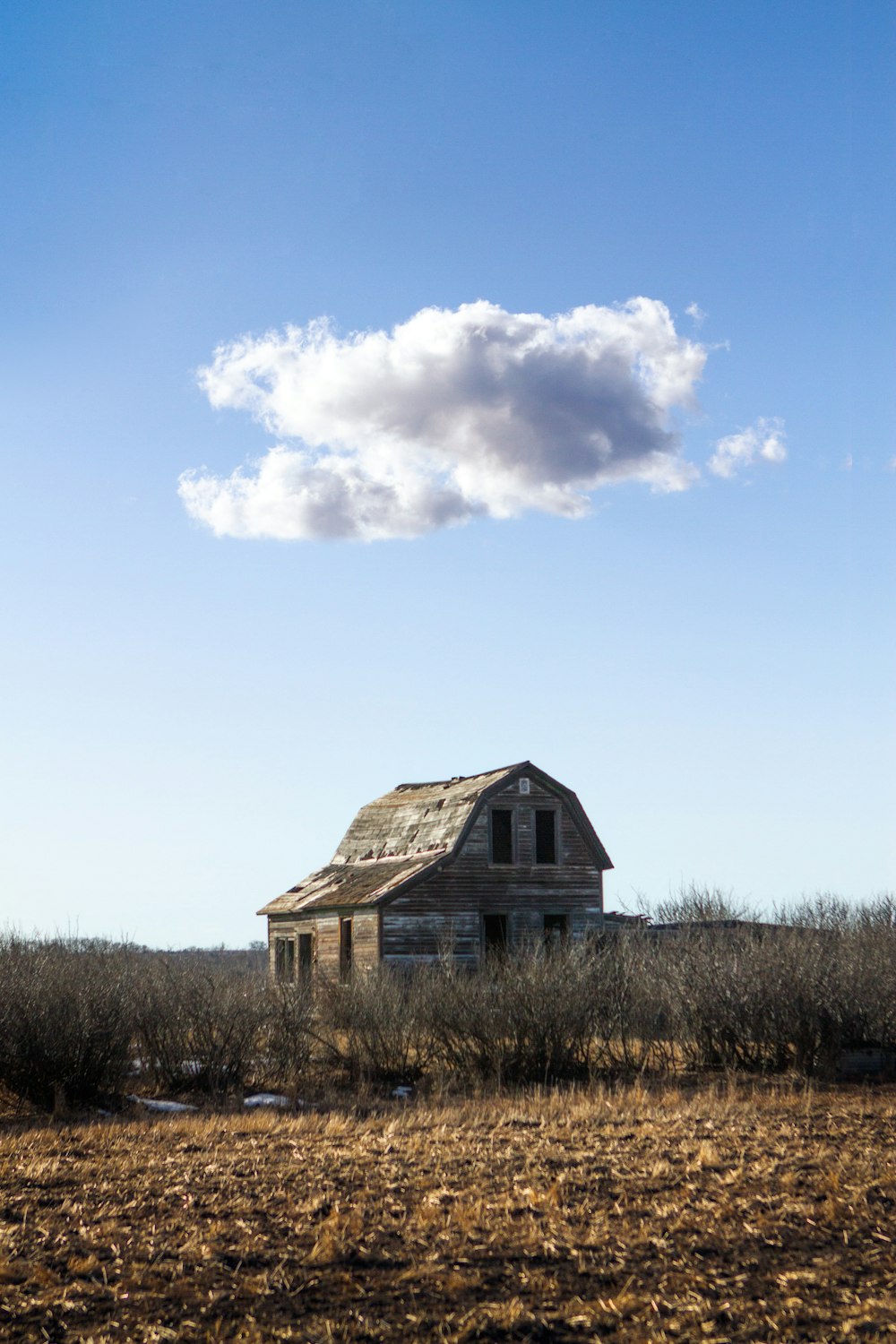 an old abandoned house in the middle of a field