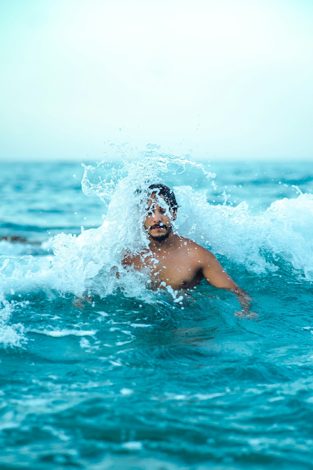 A man swimming in the ocean with a splash of water on his face photo – Free  Water Image on Unsplash