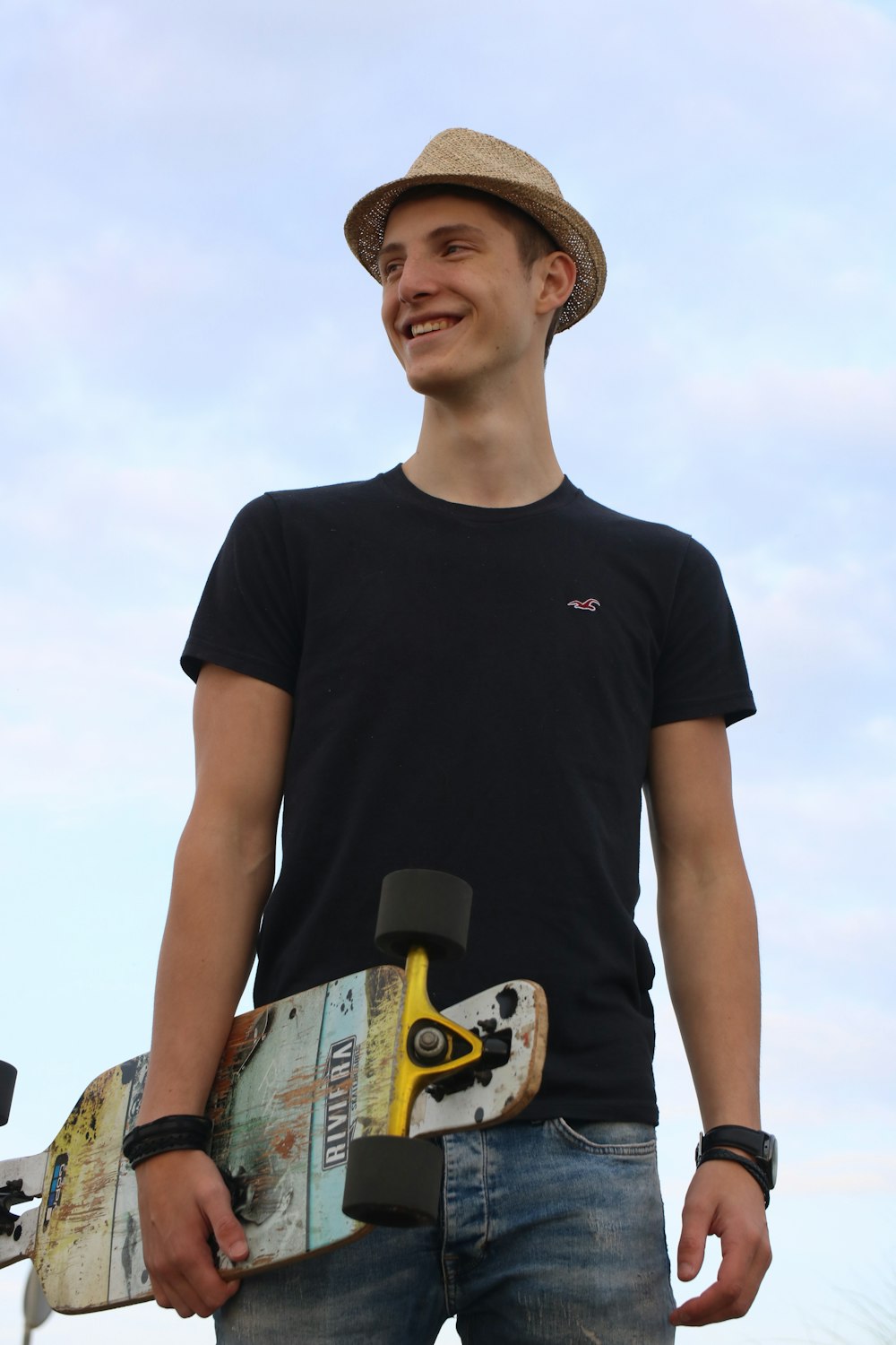 a man holding a skateboard in his right hand