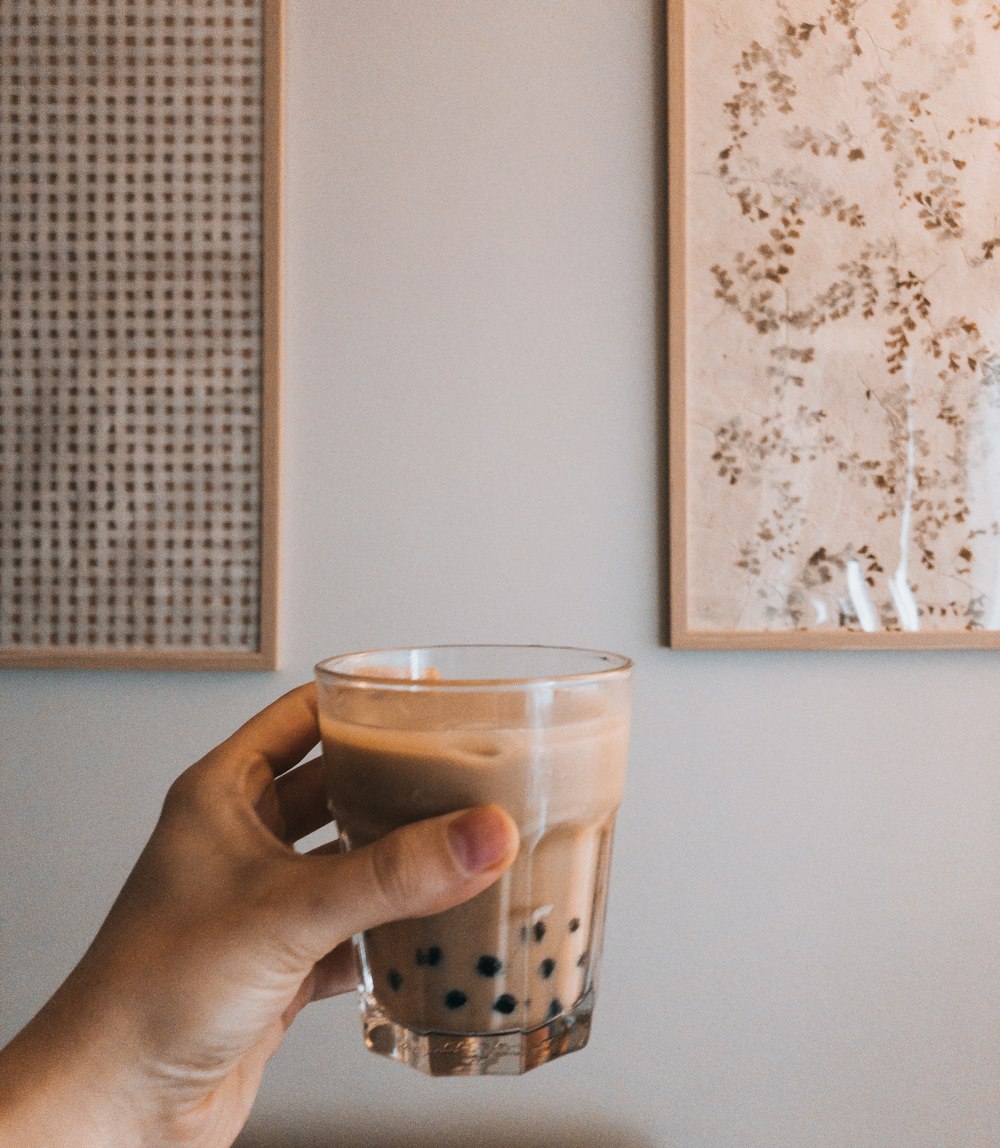 a person holding a cup of coffee in their hand