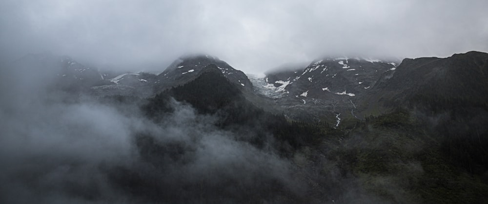 uma cordilheira coberta de nevoeiro e nuvens