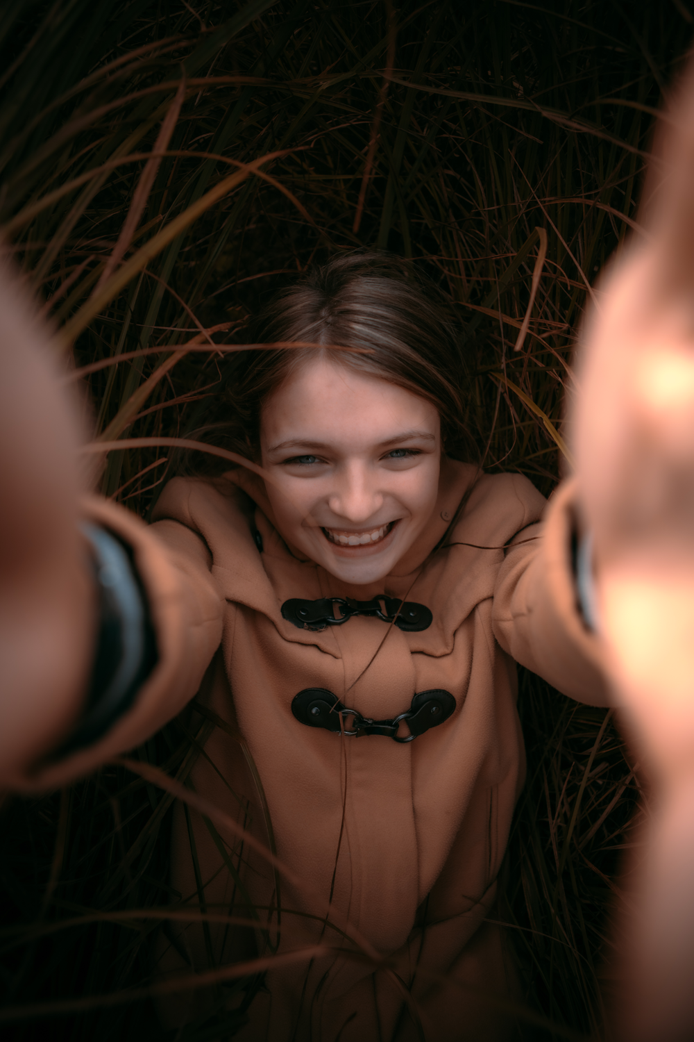 a woman in a brown coat is smiling