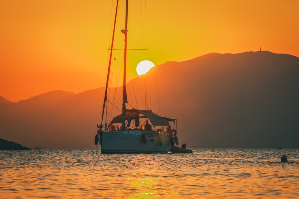 a sailboat in a body of water at sunset