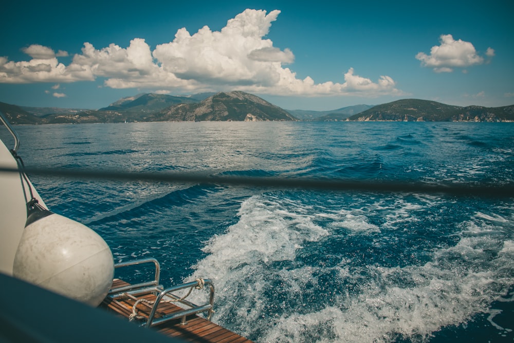 Un barco que viaja sobre un cuerpo de agua con montañas al fondo