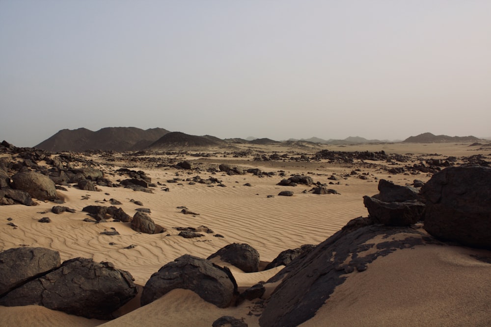 a desert with rocks and sand in the foreground
