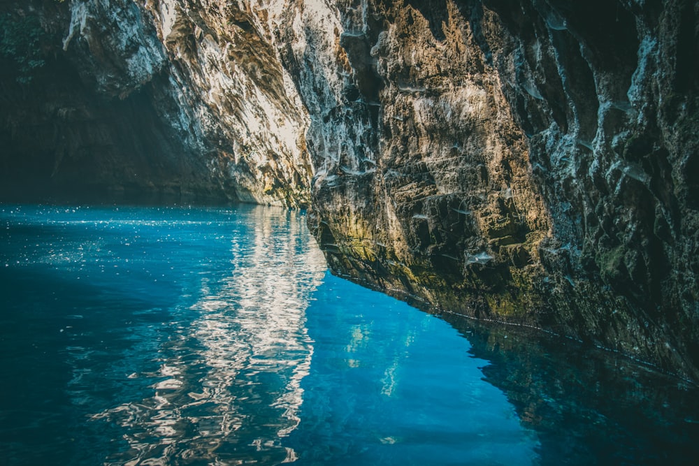 a body of water surrounded by a rocky cliff