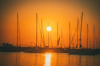 Sunset view from a luxury yacht with warm orange hues reflecting on calm sea.