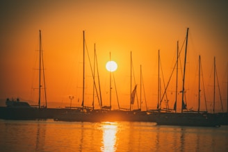 Sunset casting warm hues over a luxury yacht anchored near a remote Indonesian island.