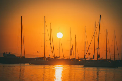 Sunset casting warm light over a yacht anchored peacefully in a quiet cove.