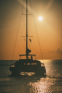 a boat is sailing in the ocean at sunset