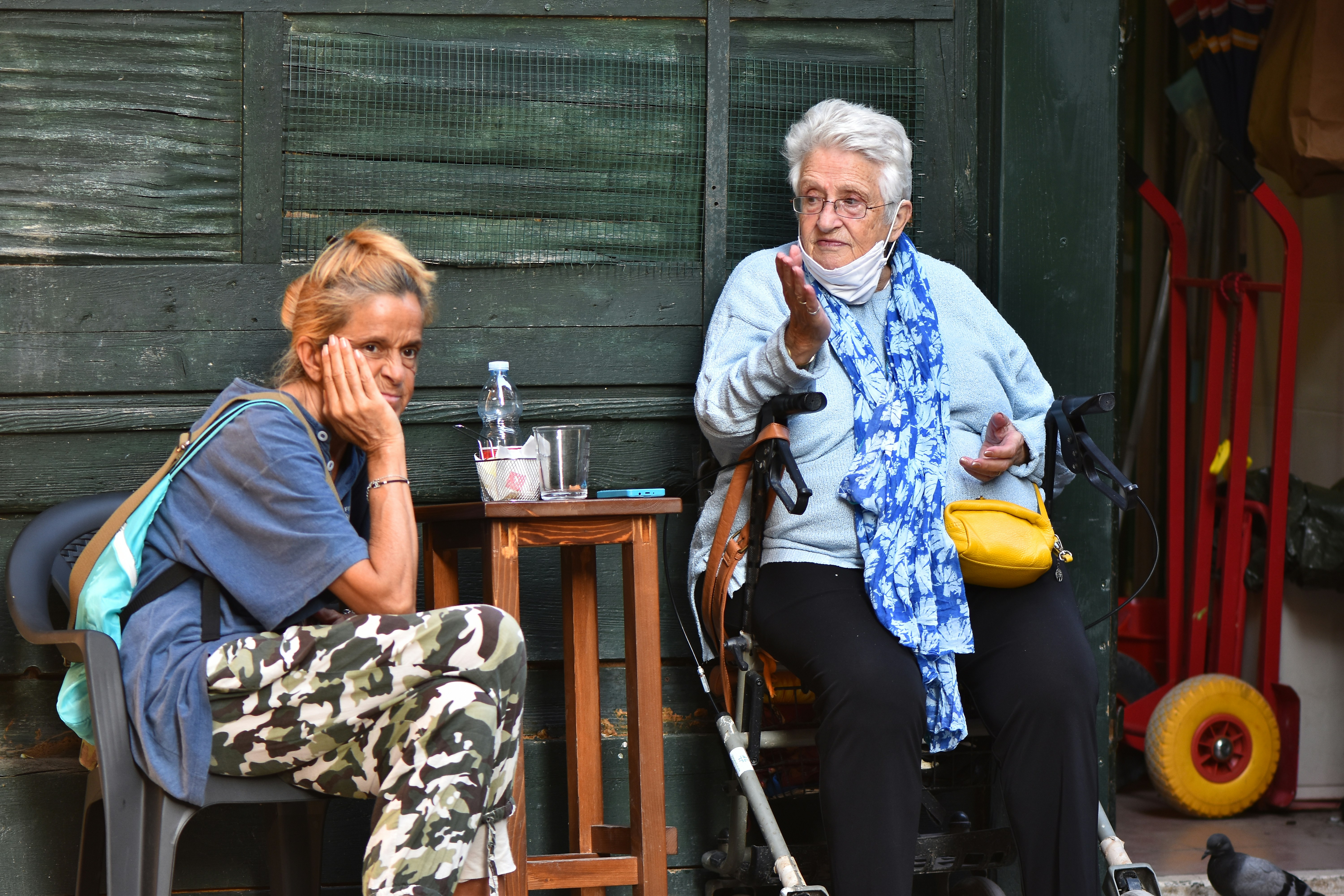 a woman sitting next to a woman sitting at a table, 