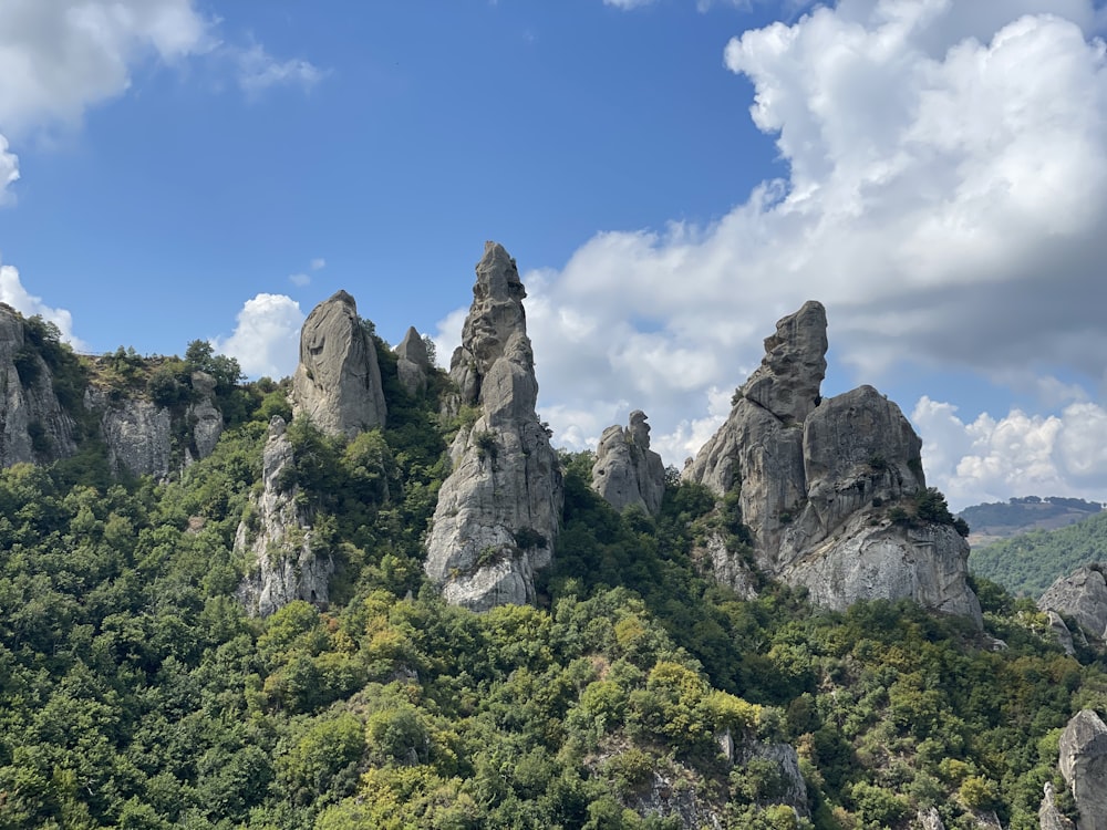 a group of rocks sitting on top of a lush green hillside