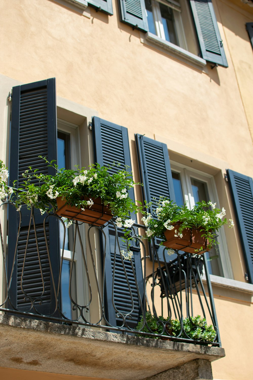 a balcony with two planters with flowers on them