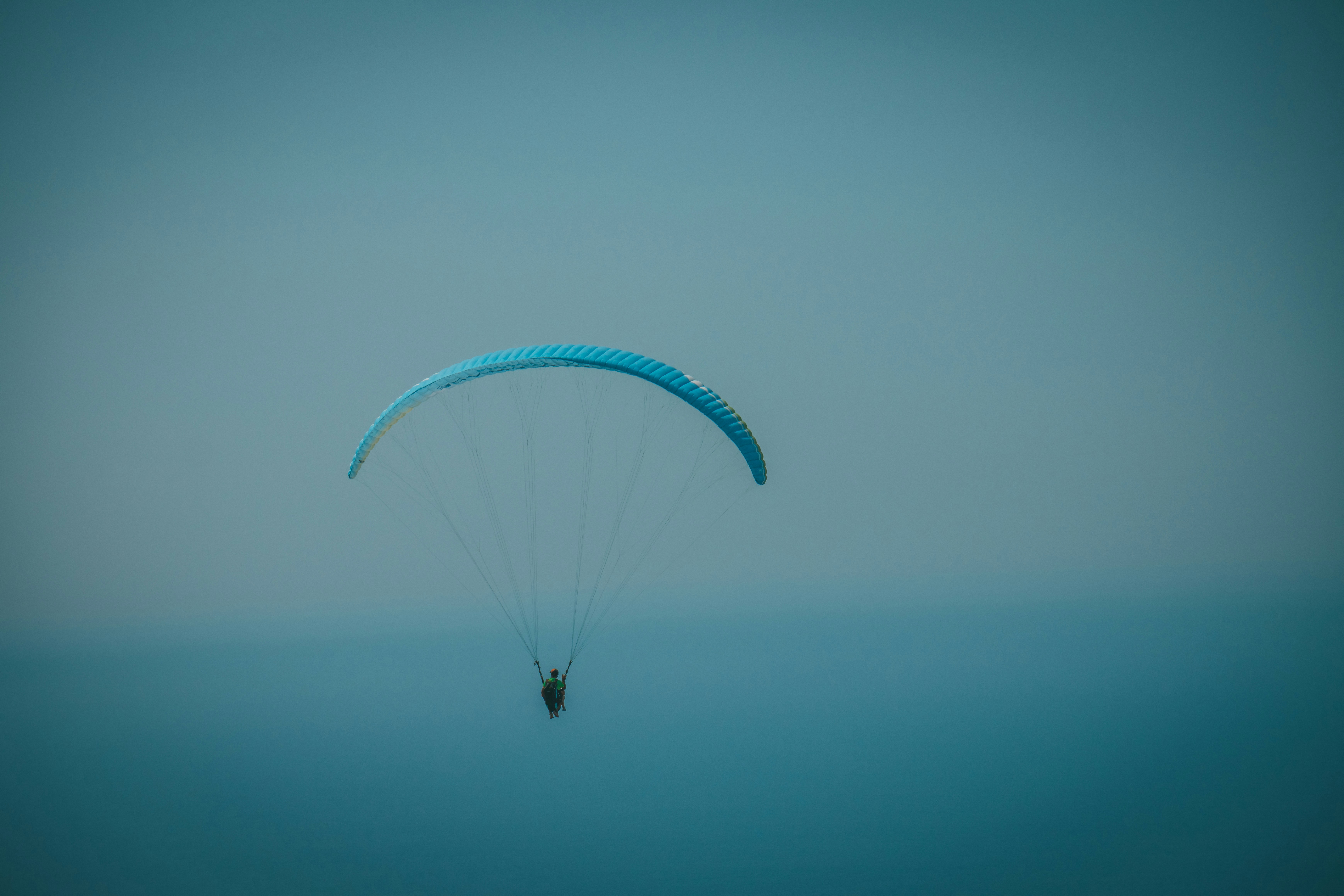 a person parasailing in the ocean on a foggy day