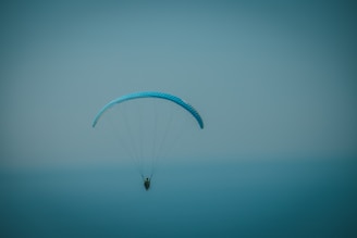 a person parasailing in the ocean on a foggy day