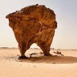 a large rock in the middle of a desert