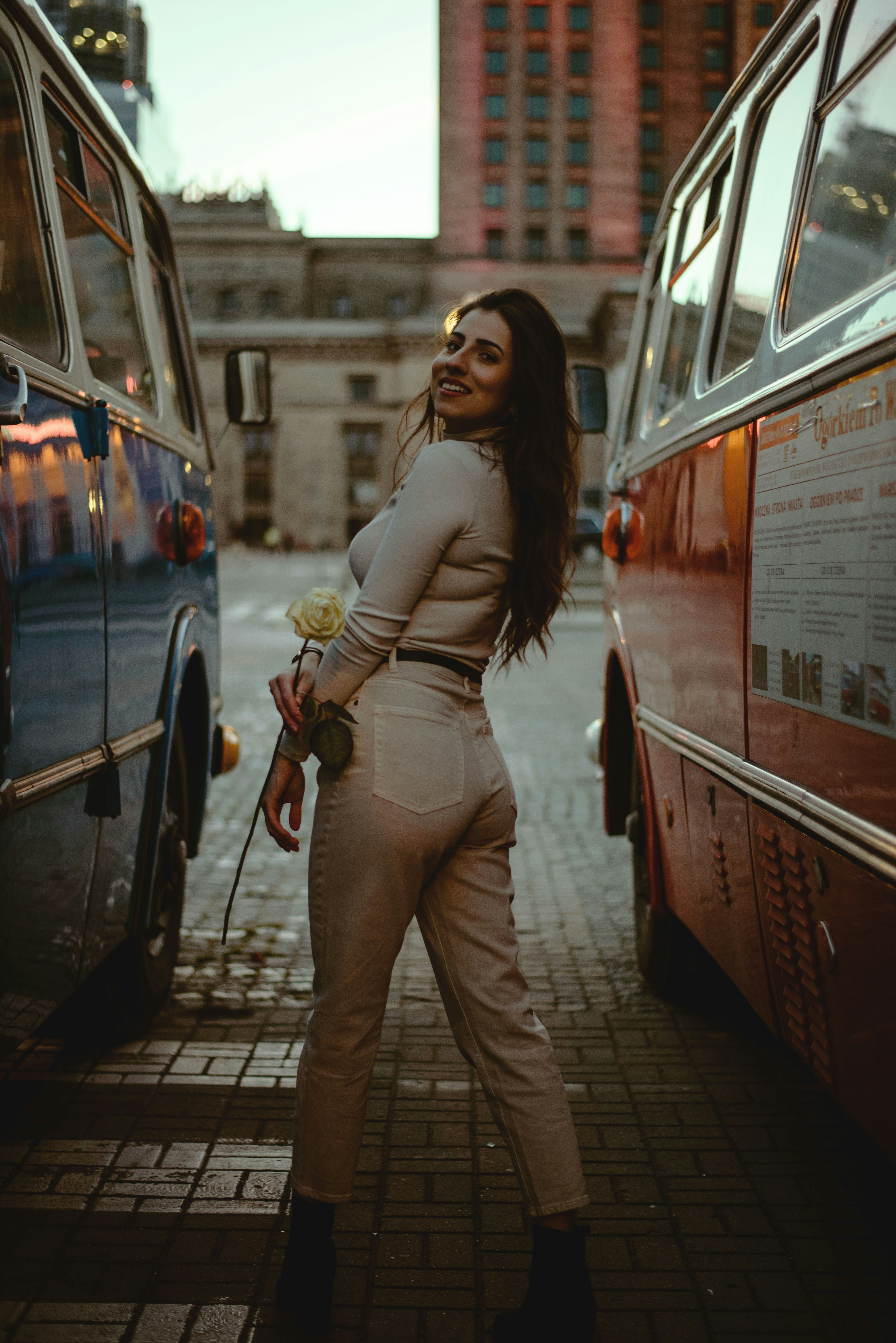 a woman standing next to a bus on a street