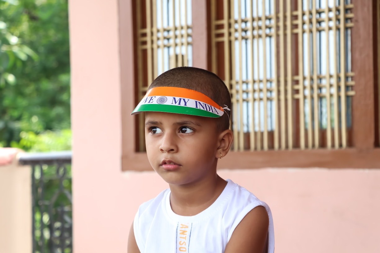 a young boy wearing a hat with a flag on it