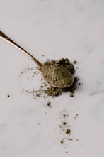 a spoon filled with dirt sitting on top of a white counter