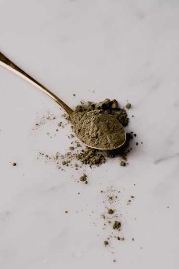 a spoon filled with dirt sitting on top of a white counter