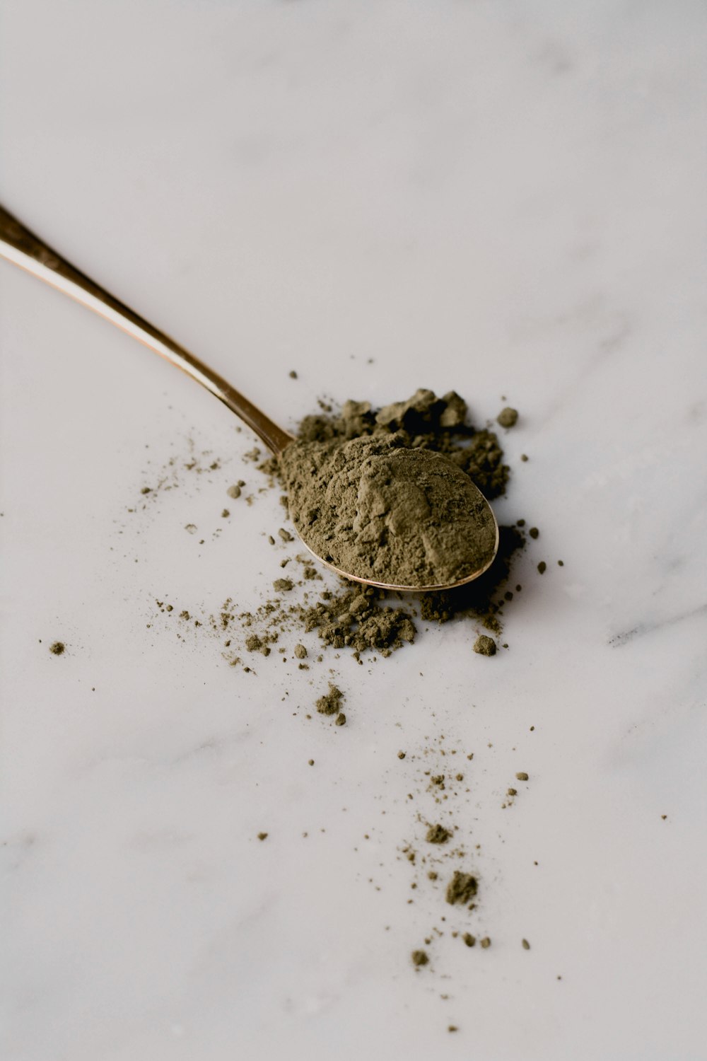 a spoon filled with dirt sitting on top of a white counter