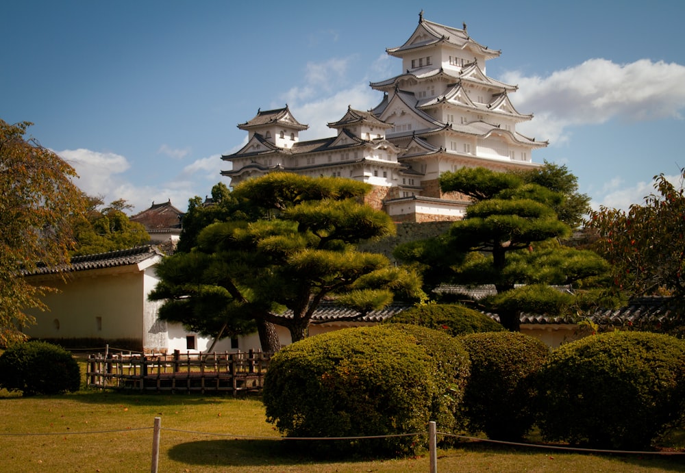 a tall white building sitting on top of a lush green field