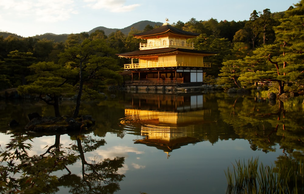 a building sitting on top of a lake next to a forest