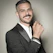 A stylish man wearing a sleek gold bracelet from Altınişık, smiling confidently.