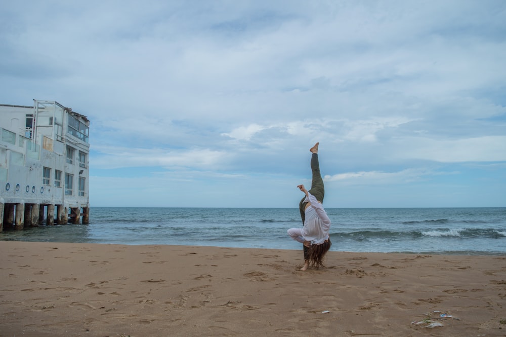 a person doing a handstand on the beach