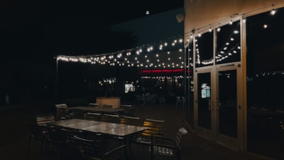 Outdoor seating area with string lights creating a welcoming atmosphere at dusk.