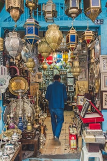 a man walking through a store filled with lots of items