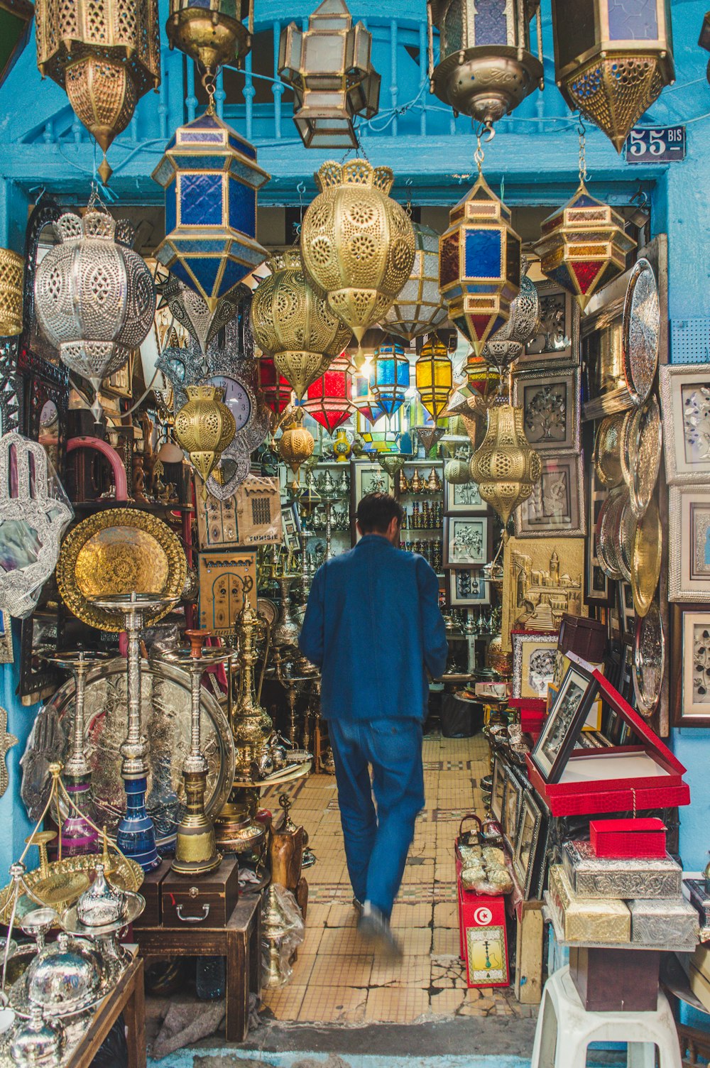 a man walking through a store filled with lots of items