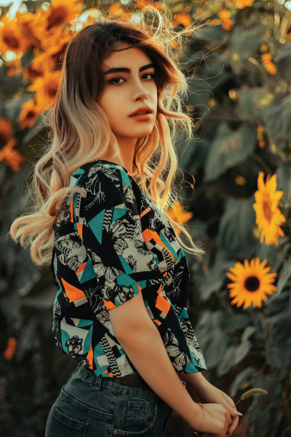 a woman standing in front of a field of sunflowers