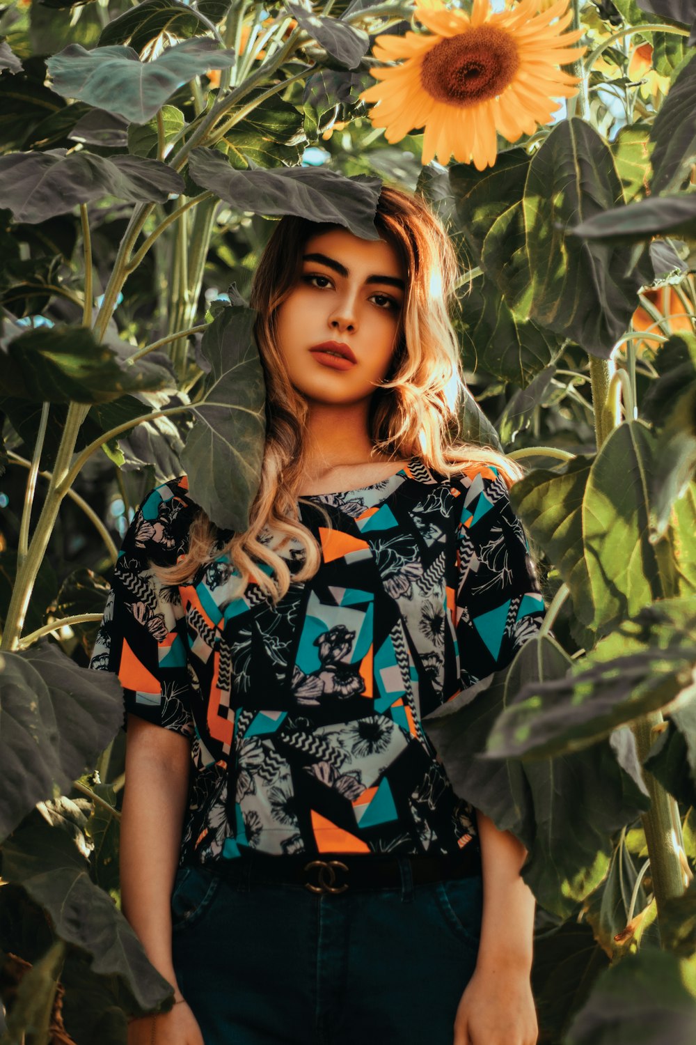 a woman standing in front of a sunflower