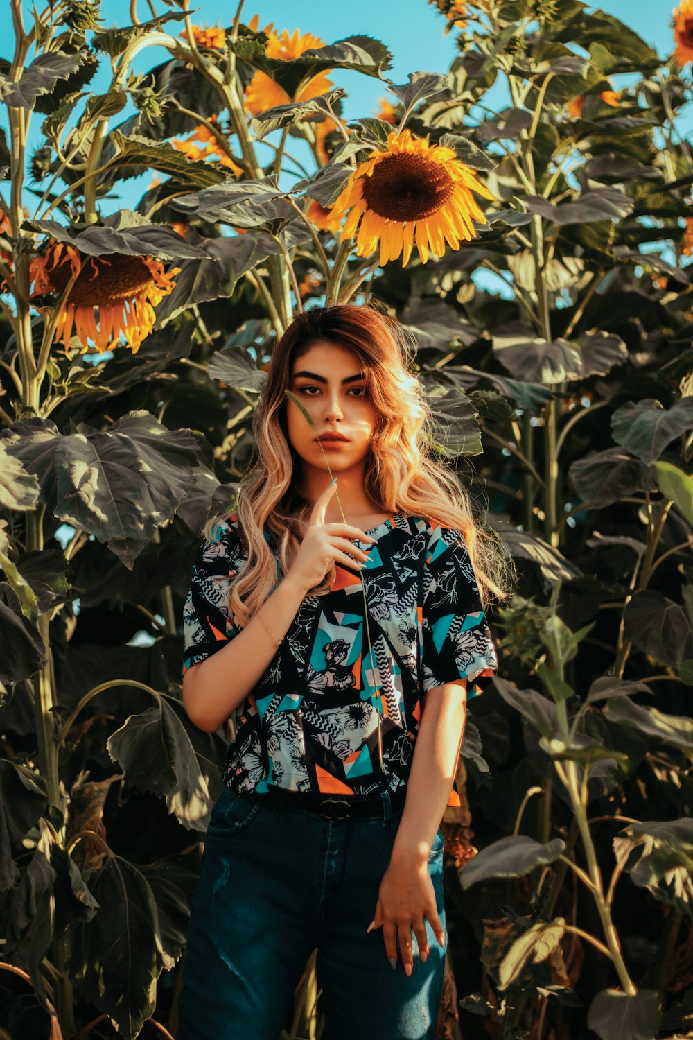 a woman standing in front of a field of sunflowers